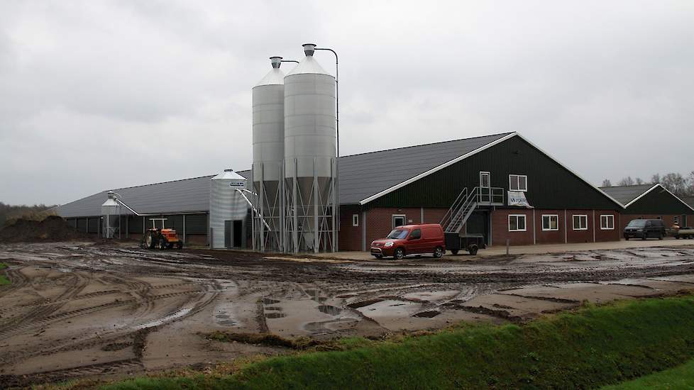 Een overzicht van de voor- en zijkant van de nieuwe stal met vooraan de twee metalen silo’s met de speciale onderbak waarmee ontmenging van het voer voorkomen moet worden.