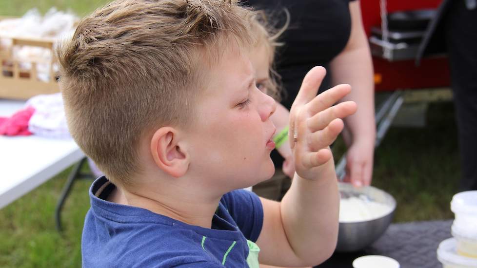 Eén van de deelnemers likt zijn hand af, waarvan hij stukjes koeientong met veel enthousiasme proefde.