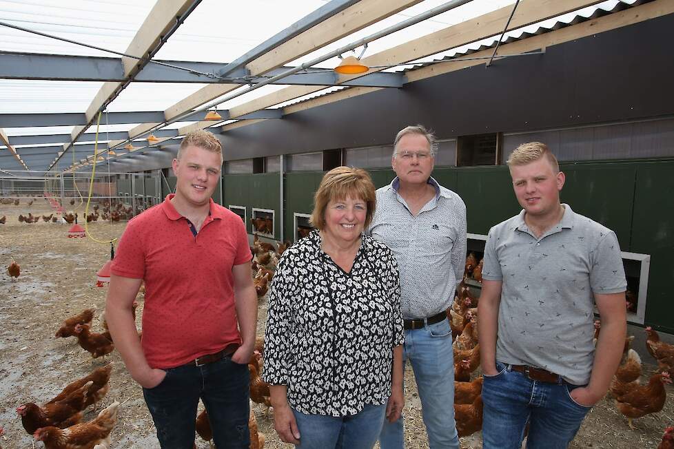 Dirk (22), moeder Jenneke (55), vader Hergen (60) en André (22) Smid in de overdekte uitloop van hun omgebouwde twee sterren Beter Leven stal.