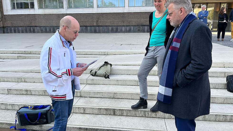 De Gelderse gedeputeerde Peter Drenth luistert naar het verhaal van boer Henk Oonk voor het provinciehuis in Arnhem. Op de achtergrond Irene van der Marel.