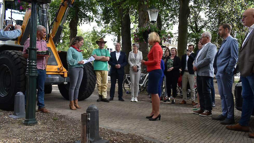 De burgemeester krijgt namens alle aanwezigen een kratje aardbeien aangeboden van Wijchense grond.