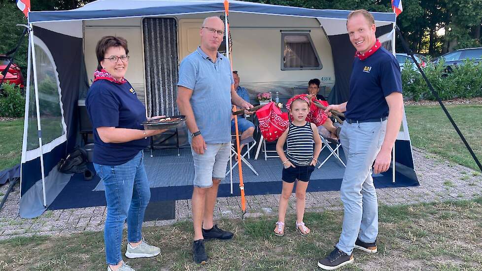 Melkveehouders Dianne Vedders (links) en Huub Kamphuis (rechts) overhandigen een knapzak aan vakantieganger André Kuik (midden).