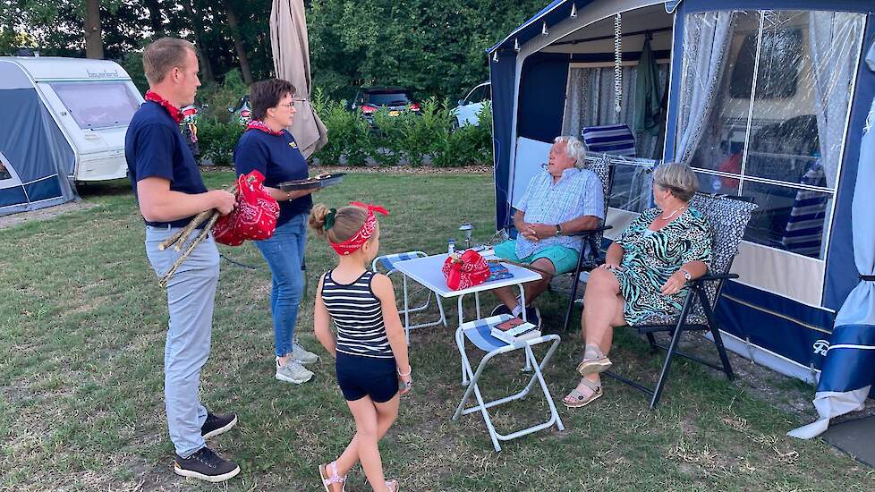 De melkveehouders in gesprek met campinggasten. De man geeft aan het nieuws over de boeren nauwlettend te volgen.