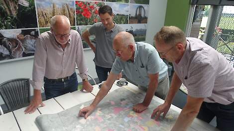 Het ‘motorblok’ (vlnr Cor Bosch, Gerko Hopster, Gerrit Tuten en Rudie Freriks) van het na 15 jaar afgeronde project ‘Kavels voor Koeien’ in Salland bekijken de indelingskaart van het eerste kavelruilproject Luttenberg-Mariënheem.