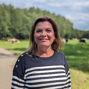 Minister Van der Wal op het platteland bij grazende koeien.