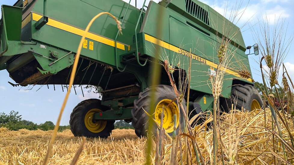 De wintergerst wordt geoogst met een John Deere 2258.