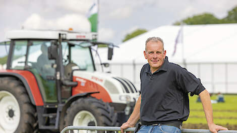 Melkveehouder Ard Looman op het festivalterrein van de Oosterwijkse Pinksterfeesten. Op de achtergrond maakt een trekker de baan voor de TrekkerTrek gereed.