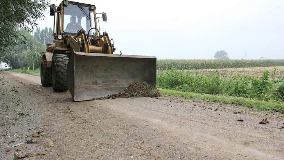 Vader Reijmer maakt na elke vracht die van de zware rivierklei af komt, de weg weer schoon.