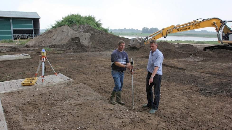 De laatste hand wordt achter de stal nog aan de terp gelegd. Op de achtergrond de Rijn. Rechts Ton, links zijn neef Victor waarmee hij samenwerkt.